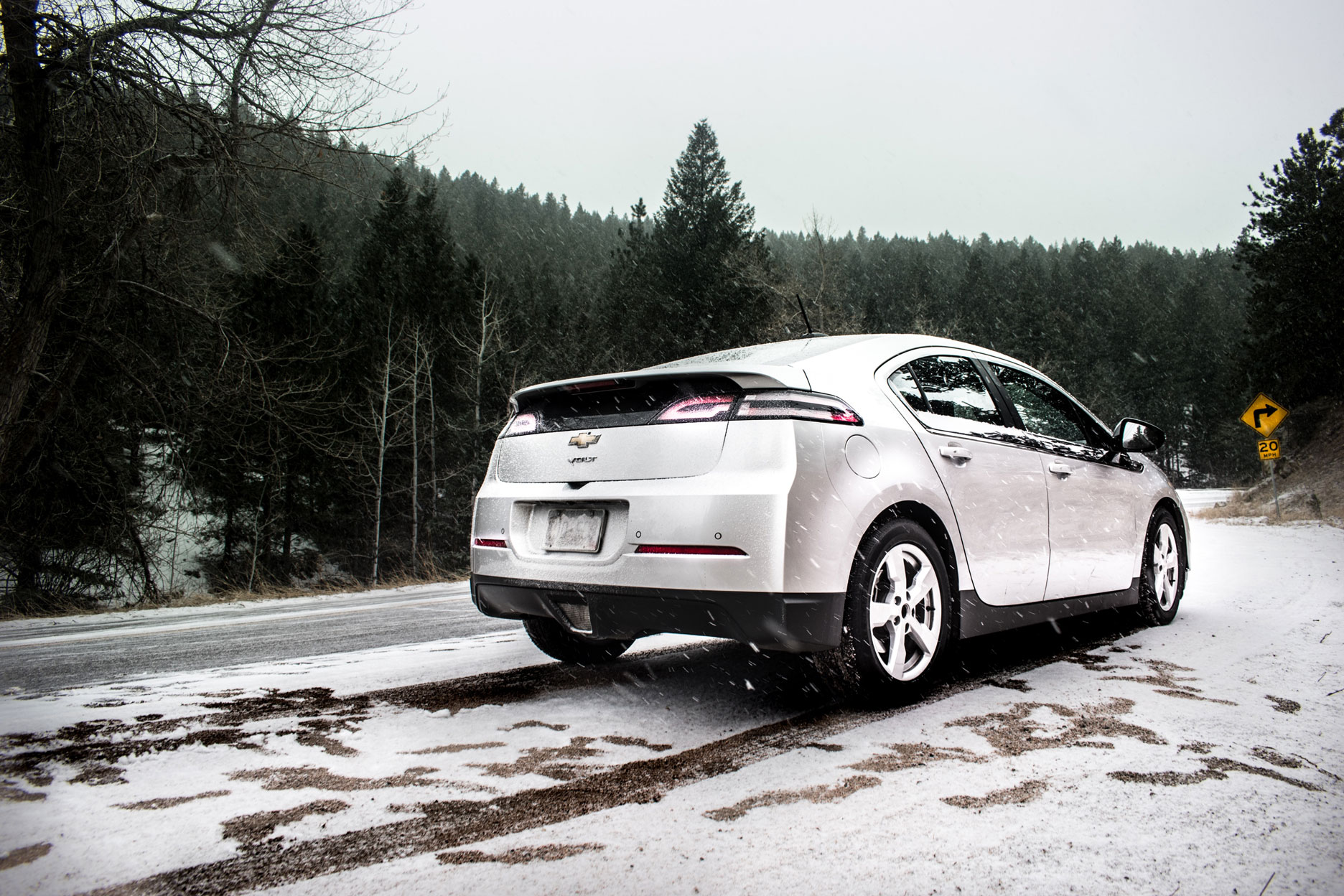 Passenger car driving through snow in a forest