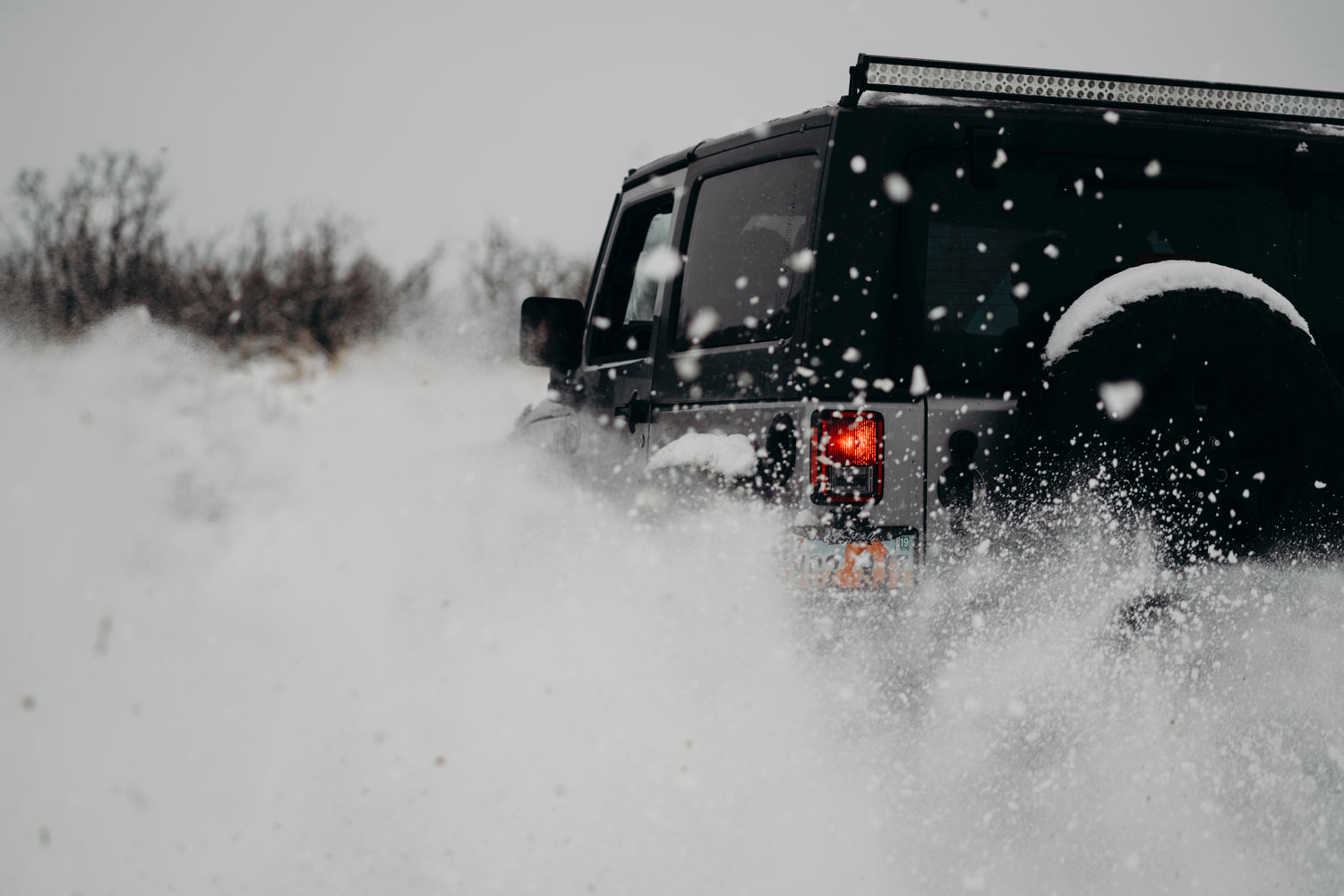Jeep running through the snow with extra traction because of winter tires