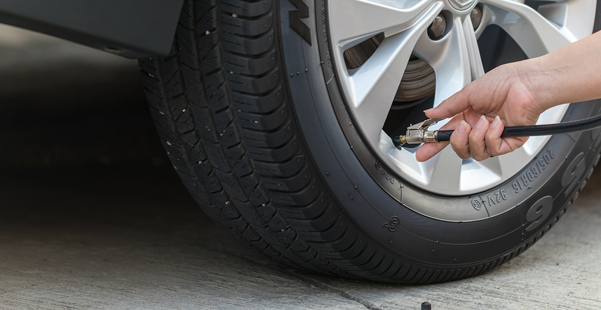 A woman airs up her tires after seeing her low tire pressure warning light come on.