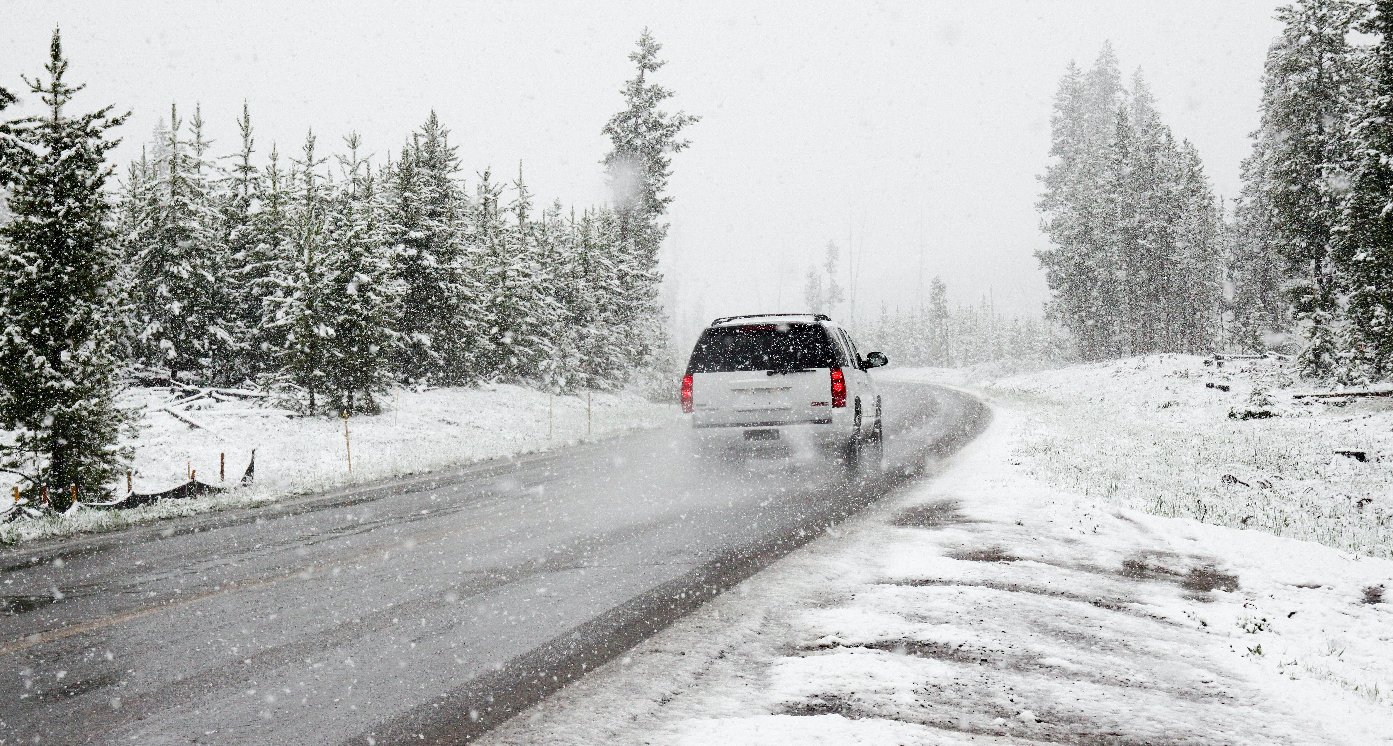 Car driving during snowy weather conditions and causing tire wear.