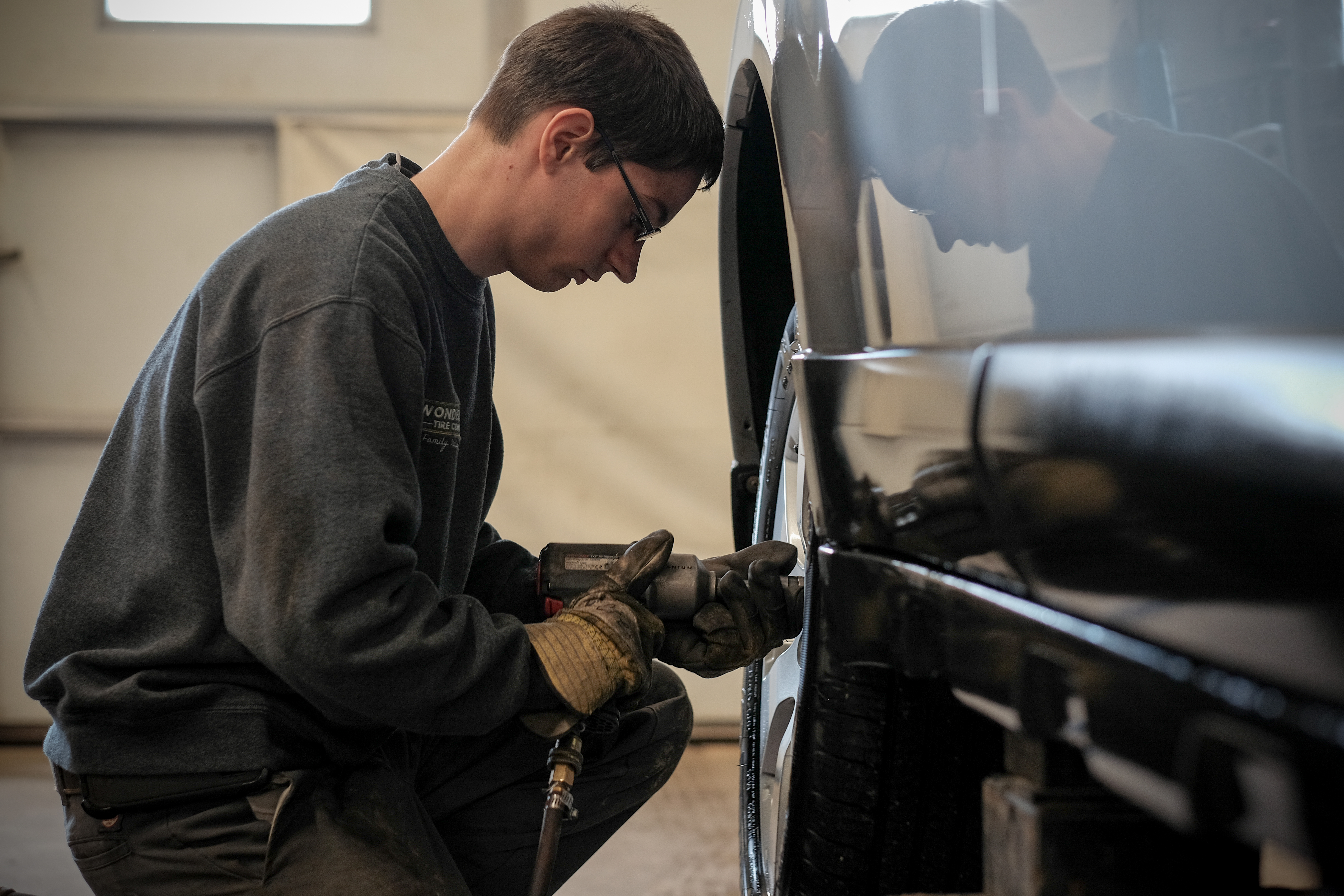 Tire technician at Wonderland Tire working on a car tire in Byron Center, MI.