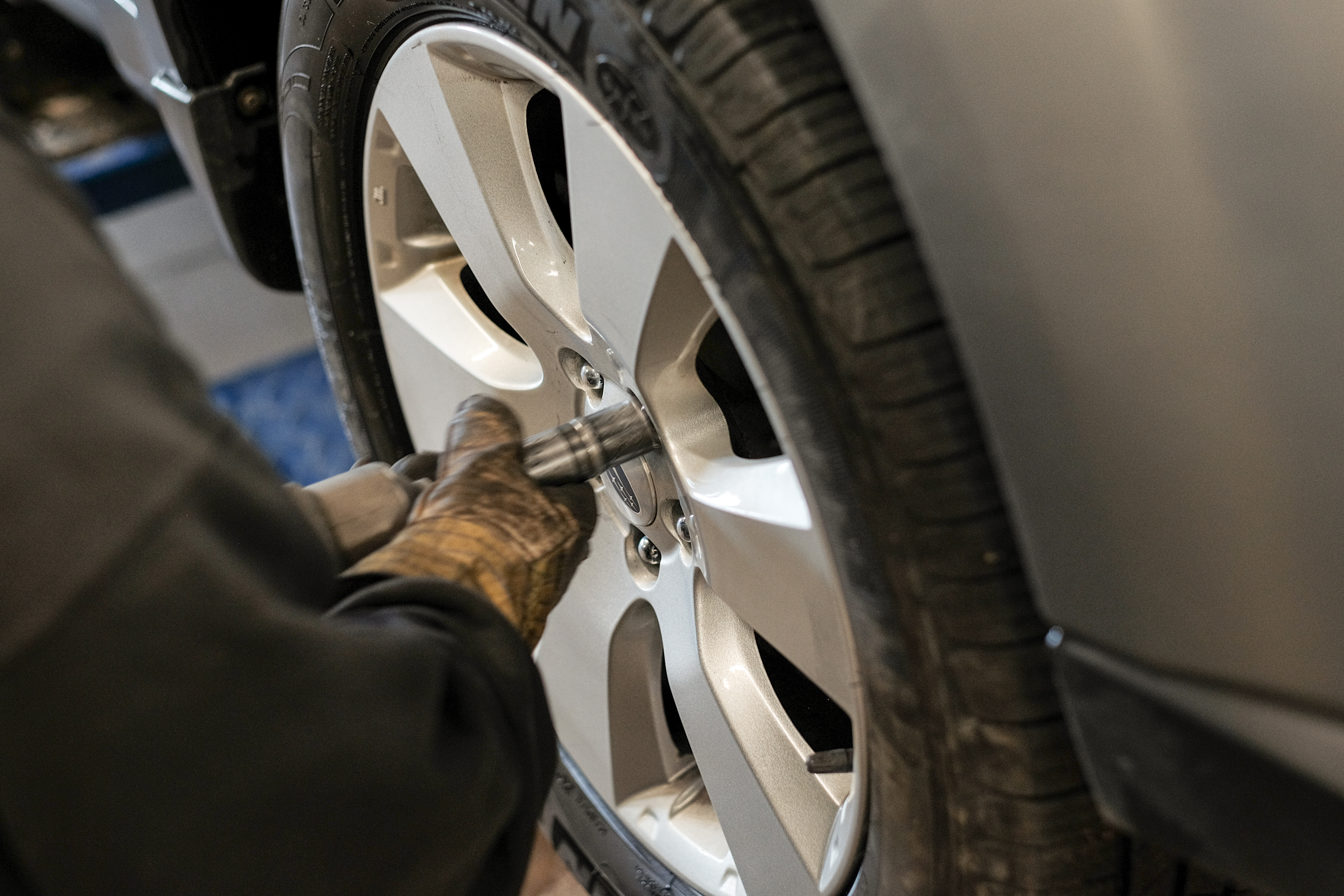 A professional Wonderland Tire technician is replacing a car's tire during a tire rotation service at their Byron Center location