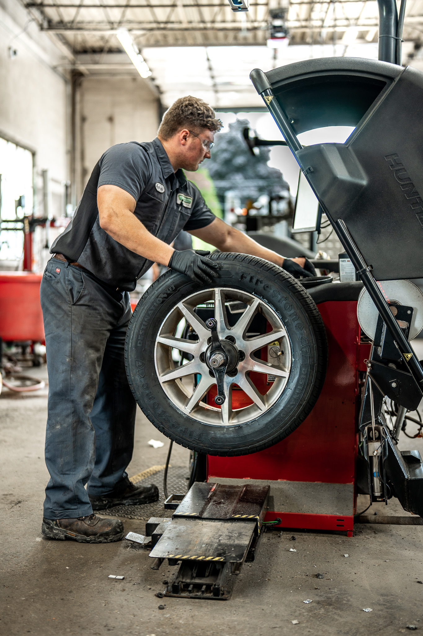 A Wonderland Tire employee balances a car tire using the Hunter Road Force Balancing Machine.