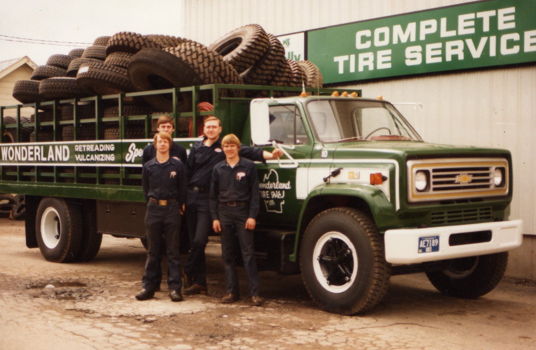 The founders of Wonderland Tire stand in front of a truck full of tires.