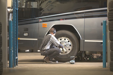 Service technician cleaning RV wheels
